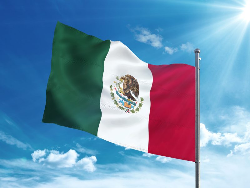 Mexico flag waving in the blue sky Mexican flag waving in the blue sky