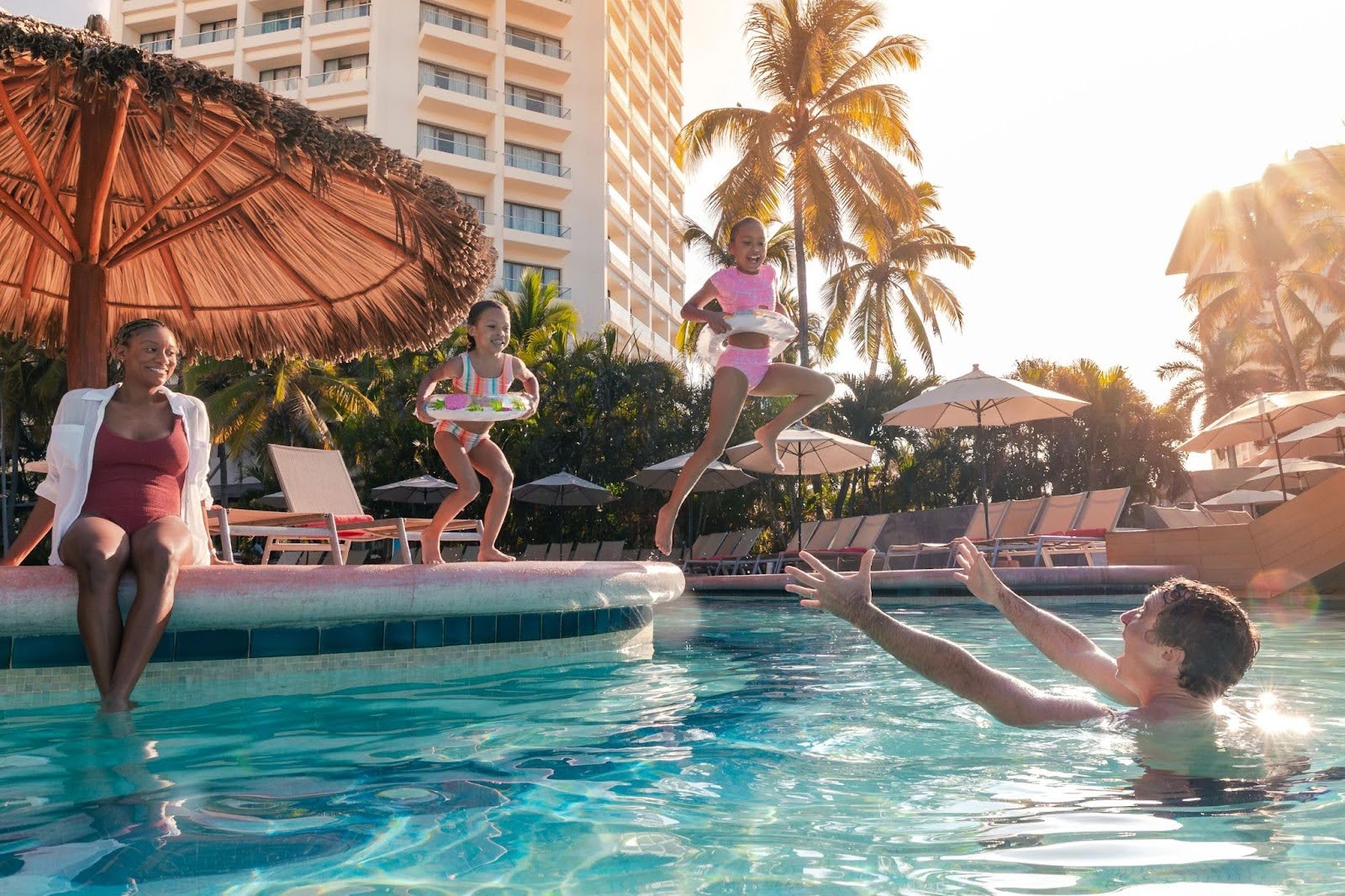 Family playing together at the pool