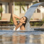 woman enjoying hydrotherapy in a spa style pool. secrets playa mujeres golf & spa resort.