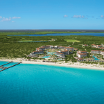 aerial view of the resort facing a white sand beach and turquoise sea secrets playa mujeres golf & spa resort.