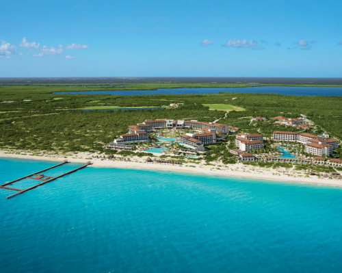 aerial view of the resort facing a white sand beach and turquoise sea secrets playa mujeres golf & spa resort.