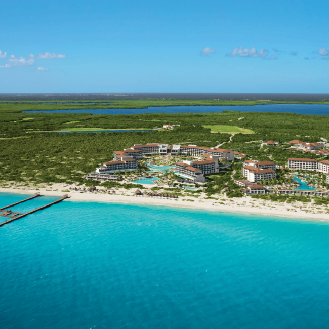 aerial view of the resort facing a white sand beach and turquoise sea secrets playa mujeres golf & spa resort.