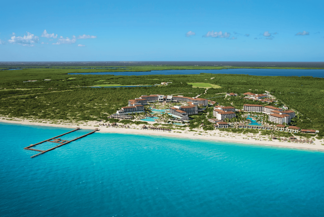 aerial view of the resort facing a white sand beach and turquoise sea secrets playa mujeres golf & spa resort.
