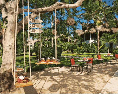 outdoor garden dining area with tropical decor and hanging swings zoetry agua punta cana